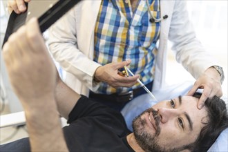 Latin man getting filler injections in aesthetic medical clinic