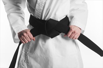 Female holding karate black belt