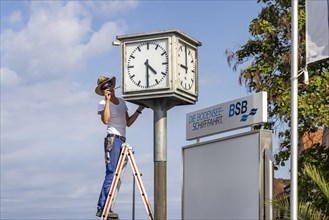 Fitter sets the time on a clock at Meersburg on Lake Constance