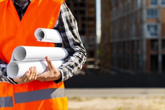 Construction engineer holding plans hands