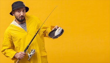 Front view fisherman holding fishing rod with catch plate