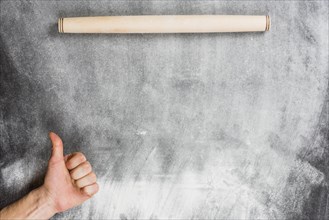 Flour background with rolling pin hands making ok sign