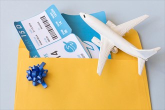 Airplane tickets document case near toy aircraft