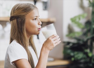 Side view girl drinking glass milk