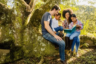 Family reading together tree trunk