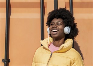 Portrait young woman with headphones jumping 1