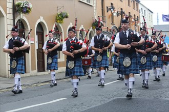 Irish bagpipers in kilts march at the head of the final parade to mark the close of Fleadh Cheoil na hEireann