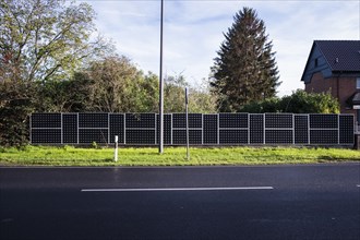 Solar panels as a garden fence and privacy screen of a house on a street in Langenfeld