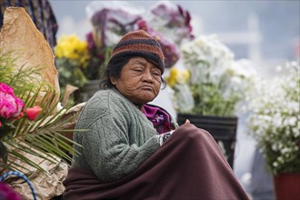 Old local Mayan K'iche woman selling flowers on market day in the town Chichicastenango
