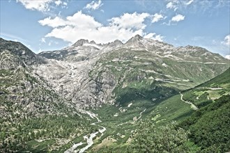 Photo with reduced dynamic saturation HDR of view on in the background Rhone glacier in front river Rotten Rhone right mountain pass alpine mountain road alpine road road pass road pass on Furka Furka...