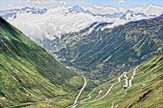 Photo with reduced dynamic saturation HDR of view on in the background Grimselpass front mountain pass alpine mountain road alpine road road pass road pass on Furka Furka pass above above tree line in...