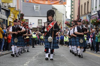 A pipe band marches at the head of the final parade to mark the closing of Fleadh Cheoil na hEireann
