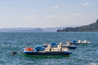 Three pedal boats anchored on Lake Garda