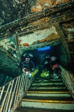 Two Tec divers Tech divers with scuba for technical diving mixed gas diving swim down staircase in for divers sunken shipwreck Karwela