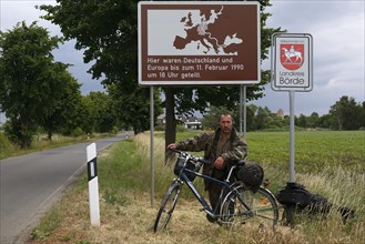 Cycle tourist in front of a plaque on the inner-German division