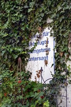 Sign -Parking for unauthorised strictly prohibited- surrounded with ivy