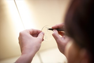 An optician inscribes a spectacle lens