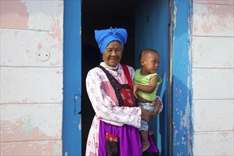 Grandmother with child in front of her house in township near Swakopmund