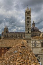 Dark clouds over the Siena Cathedral with its black and white striped marble facade