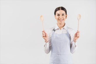Female apron smiling holding spoons