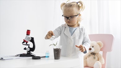 Front view cute toddler learning about science with plant microscope