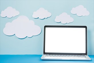 Laptop near paper clouds