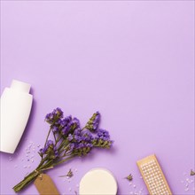 Flat lay frame with white bottle lilac flower