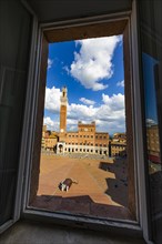 Spring clouds over the Piazza del Campo with the bell tower Torre del Mangia and the town hall Palazzo Pubblico