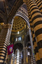 Black and white striped marble columns in the cathedral below the dome with starry sky