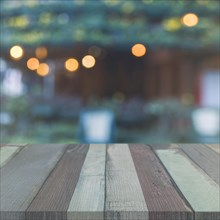 Wooden table top front garden with blurred bokeh lights