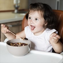 Adorable young girl eating cereals