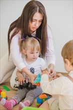 Brunette woman playing with kids