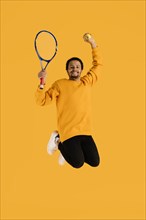 Portrait young man jumping with tennis racket