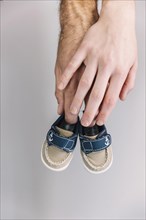 Hand holding baby shoes