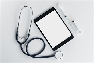 Overhead view stethoscope digital tablet syringe isolated white background