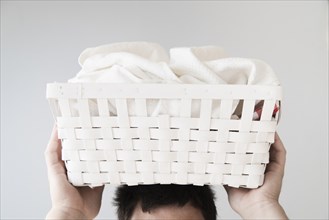 Front view person holding laundry basket head