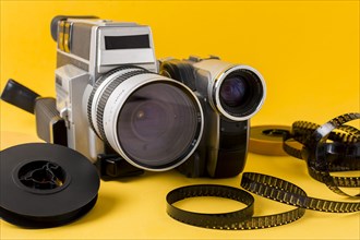 Modern camera film reel film strips yellow background