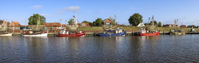 Panorama photo crab cutter in the harbour of Greetsiel with historic houses