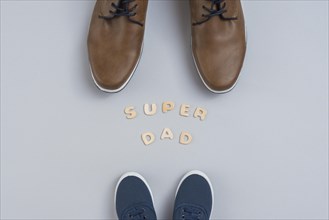 Super dad inscription with man children shoes
