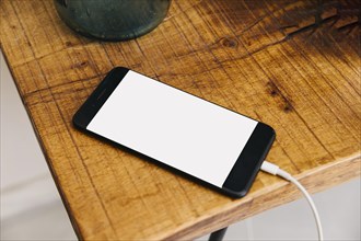 Smartphone with blank white screen wooden desk