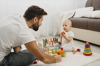 Father teaching baby play with toys