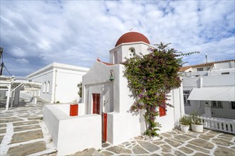White Greek Orthodox Church of St Nicholas with red roof and bougainvillea