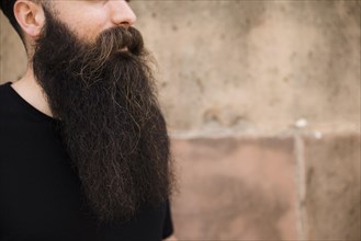 Close up bearded young man against wall