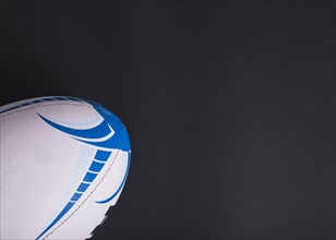Close up white rugby ball black background