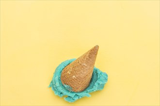 Blue ice cream cone falling yellow background