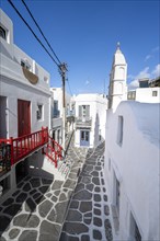 Cycladic Greek Orthodox Church and white houses with colourful doors