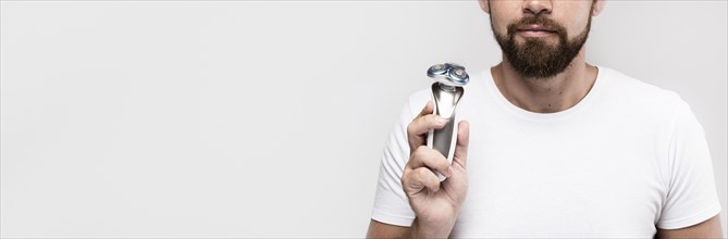Man holding electric shaver with copy space