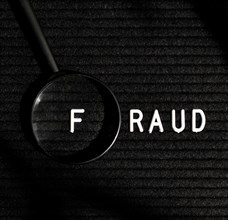 Fraud word with letter magnifying glass top view