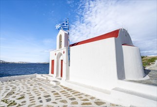Small white Cycladic chapel on the coast