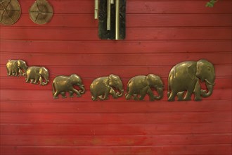 Elephant figures on a red wooden wall